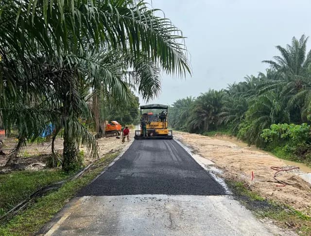 Road-surfacing equipment beside the stabilised bank.
